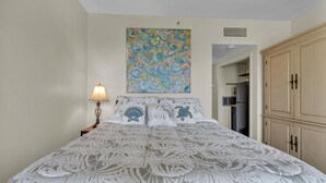 A bedroom with a bed, a nightstand, a lamp, a painting, and a wardrobe. - Charming waterfront studio in wonderful Fort Walton Beach, FL w/awesome pool (Fort Walton Beach)