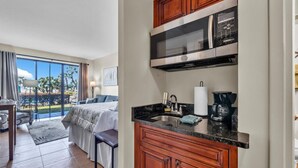 A hotel room with a kitchenette, a bed, a balcony with a view, and a dining area. - Charming waterfront studio in wonderful Fort Walton Beach, FL w/awesome pool (Fort Walton Beach)