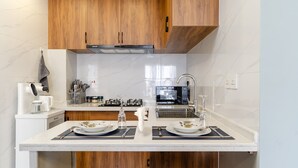 A modern kitchen with wooden cabinets, a double sink, and a microwave.