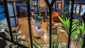 Zona d'estar moderna amb una llar de foc, diverses opcions d'asseients i una gran varietat de plantes.
