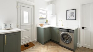 Cocina compacta con lavadora, tostadora y ventana con vistas.