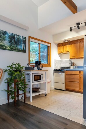 A compact kitchen with a microwave, coffee maker, and wooden cabinets. - Buena Vista Garden Studio Apartment: STR-043 (Buena Vista)