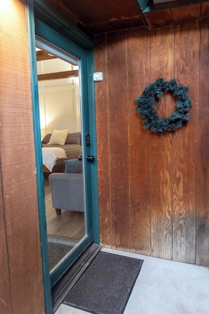 A wooden door with a green frame, a doormat, and a wreath on the wall. - Buena Vista Garden Studio Apartment: STR-043 (Buena Vista)