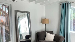 A modern bedroom with a bed, a sofa, a lamp, and a large mirror.