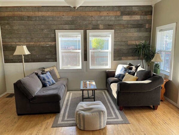 A living room with two sofas, a coffee table, and a rug.