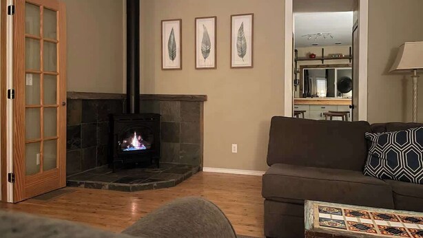 Una sala de estar con chimenea, un sofá y una mesa de centro.