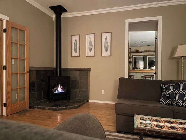Una sala de estar con chimenea, un sofá y una mesa de centro.