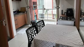 Eine kompakte Küche mit Essbereich, einem Gasherd und einer Schiebeglasdoor zum Balkon.