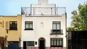Un edificio de dos plantas con un balcón, una puerta y una ventana.