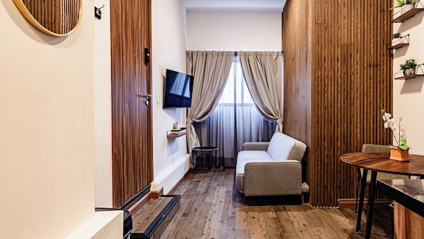 Una sala de estar moderna con un sofá, un televisor y piso de madera.