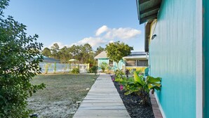 A pathway leading to a building with a blue exterior. - Charming 2-bedroom suite in soothing Navarre with AC, WiFi (Navarre)