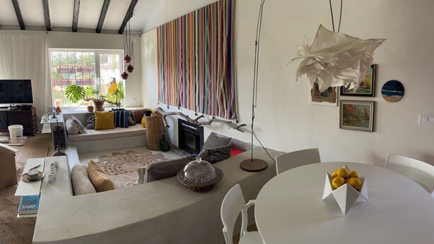 Ein modernes Wohnzimmer mit einer Couch, einem Esstisch und einem Fernseher.