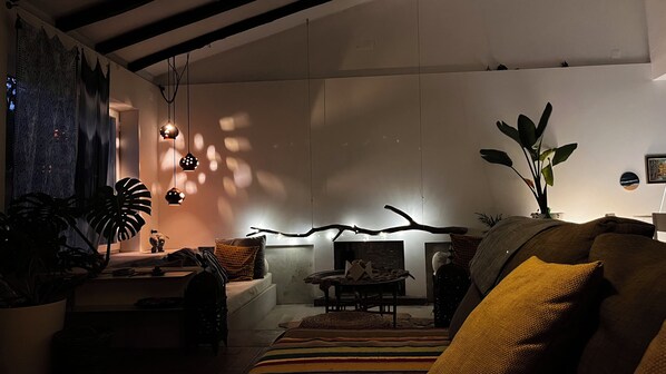 A cozy living room with a sofa, a coffee table, and a fireplace.