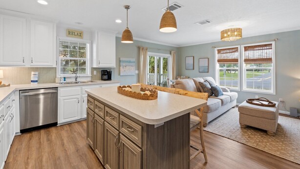 A modern kitchen with white cabinets, a central island, and pendant lighting. - Pet Friendly Beach House - Hakuna Matata (Port St. Joe)