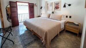 A bedroom with a bed, a nightstand, a mirror, a door, and a window. - Hotel Casa Domínguez (Taxco)