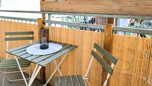 A wooden table with chairs, a round table, and a metal railing. - CaSa Apartment East Field - 5 beds, family-friendly, fully equipped (Magdeburg)