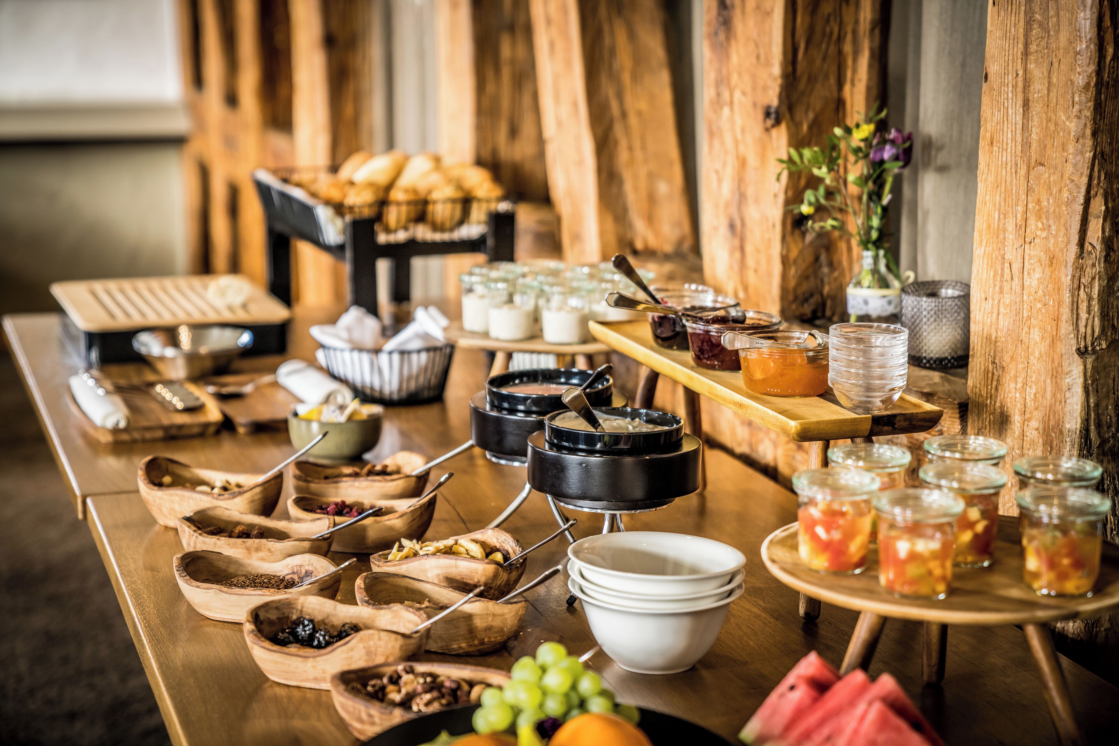 A buffet table with various food items and serving utensils.