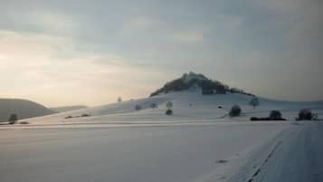 Paisaje nevado con una colina y cielo despejado.