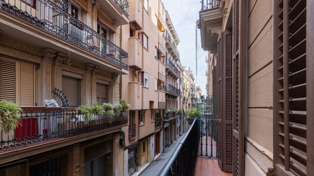 A narrow alleyway between buildings with balconies, some with plants. - PURE GRACIA, 2 bedrooms, excellent location (Barcelona)