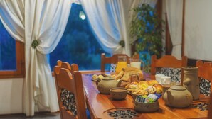 A dining table set with various breakfast items, including bread, pastries, and tea. - Rotui Apart Hotel (San Martín de los Andes)