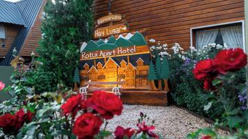 Ein Holzschild mit der Aufschrift 'Rotui Apart Hotel' und 'Bienvenidos Hay Lugar', das eine freundliche Begrüßung anzeigt.