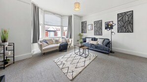 A modern living room with a sofa, a coffee table, and decorative wall art. - Modern Getaway in Gillingham (Gillingham)