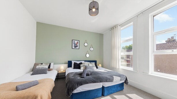 A bedroom with two beds, a large window, and a ceiling light fixture. - Modern Getaway in Gillingham (Gillingham)
