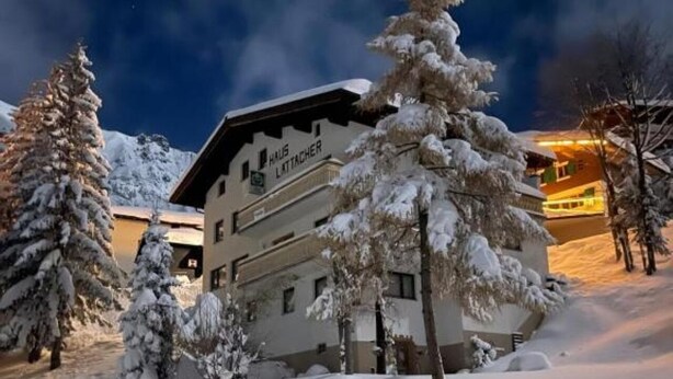 A snow-covered building with the sign "Haus Lattacher" indicating a hotel or lodging facility. - Arlberg Motel (Klösterle am Arlberg)