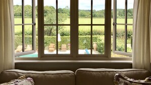 Ein Zimmer mit großem Fenster und Blick auf eine grüne Landschaft.