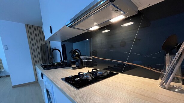 A modern kitchen with a gas stove, a coffee machine, and a kettle. - Sublime, cosy and functional studio between braga and gêres (Bico)