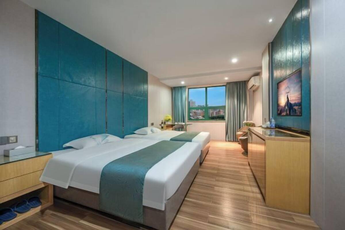 Une chambre d’hôtel avec un grand lit, un bureau, une télévision et une vue sur la ville.
