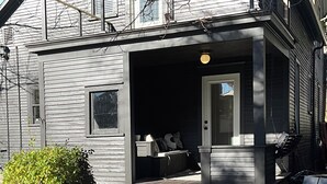 A house with a porch, outdoor seating, and a fire pit. - Modern Comfort in the Heart of Cherry Hill (Grand Rapids)