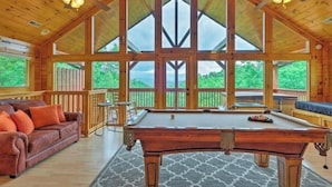 A spacious room with a pool table, a sofa, and a view of the outdoors. - Awesome Private Mountain views Resort Pool &HotTub (Sevierville)
