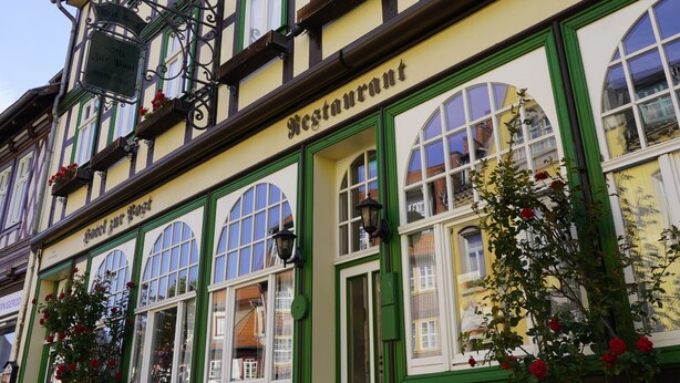 A traditional European-style building with a sign reading "Restaurant" and multiple windows with green frames. - Hotel zur Post (Wernigerode)