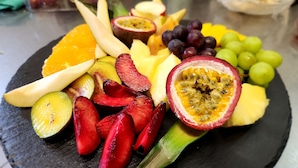A fruit platter with various fruits including passion fruit, grapes, and kiwi slices. - Hotel zur Post (Wernigerode)