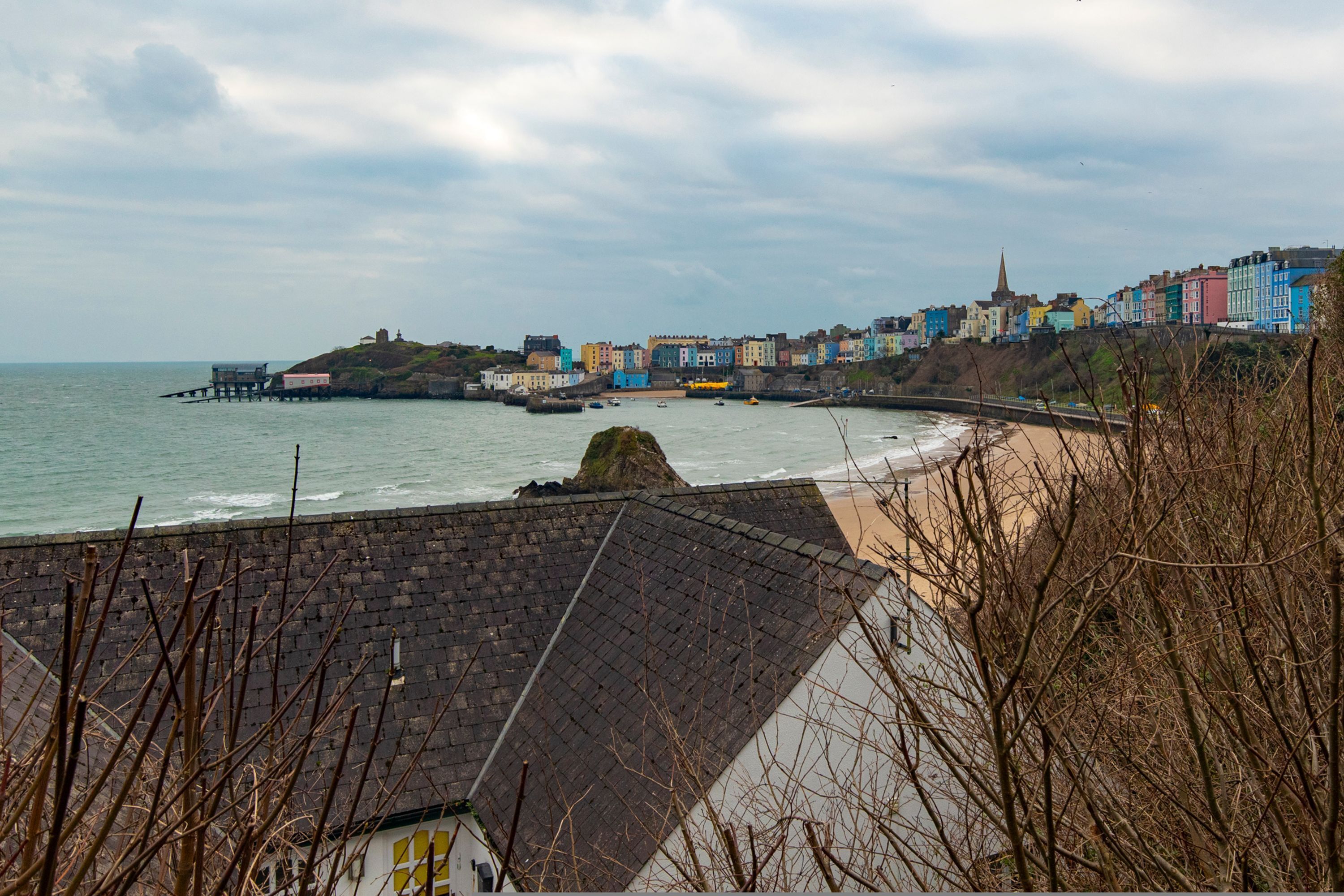 Une ville côtière avec des bâtiments aux couleurs vives, une jetée et une plage.