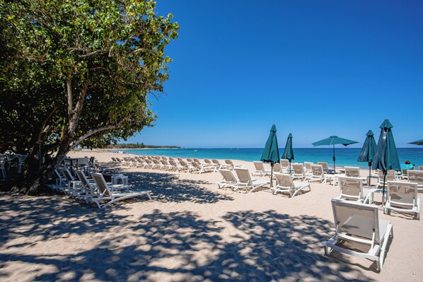 Una playa cerca, sillas reclinables de playa, toallas de playa
