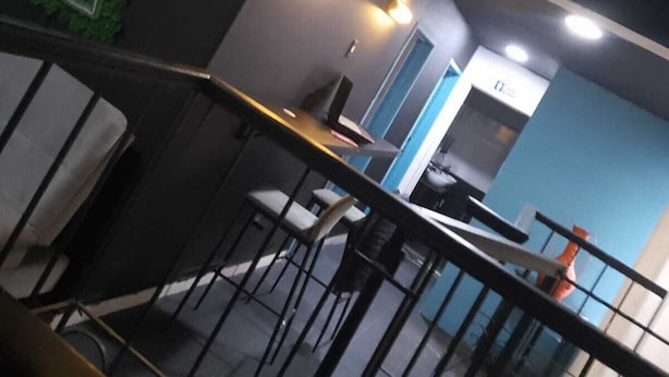 A modern interior with a bar area, seating, and a staircase. - HOTEL CAPITAL (Bogotá)