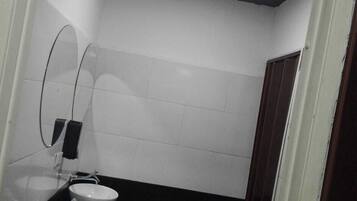 A men's restroom with two sinks, a mirror, and a sign indicating the gender.