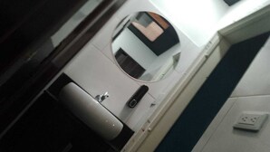 A bathroom with a sink, mirror, and a wall socket. - HOTEL CAPITAL (Bogotá)