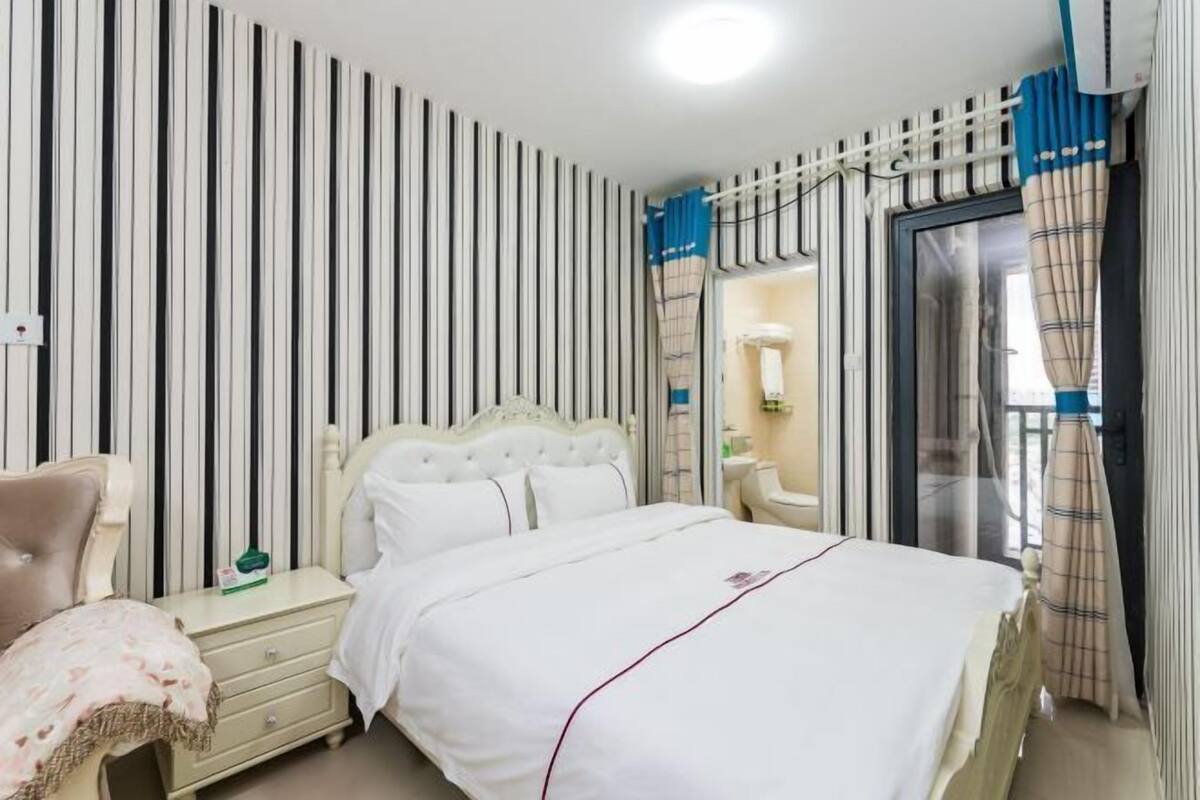 A bedroom with a bed, nightstand, and dresser.