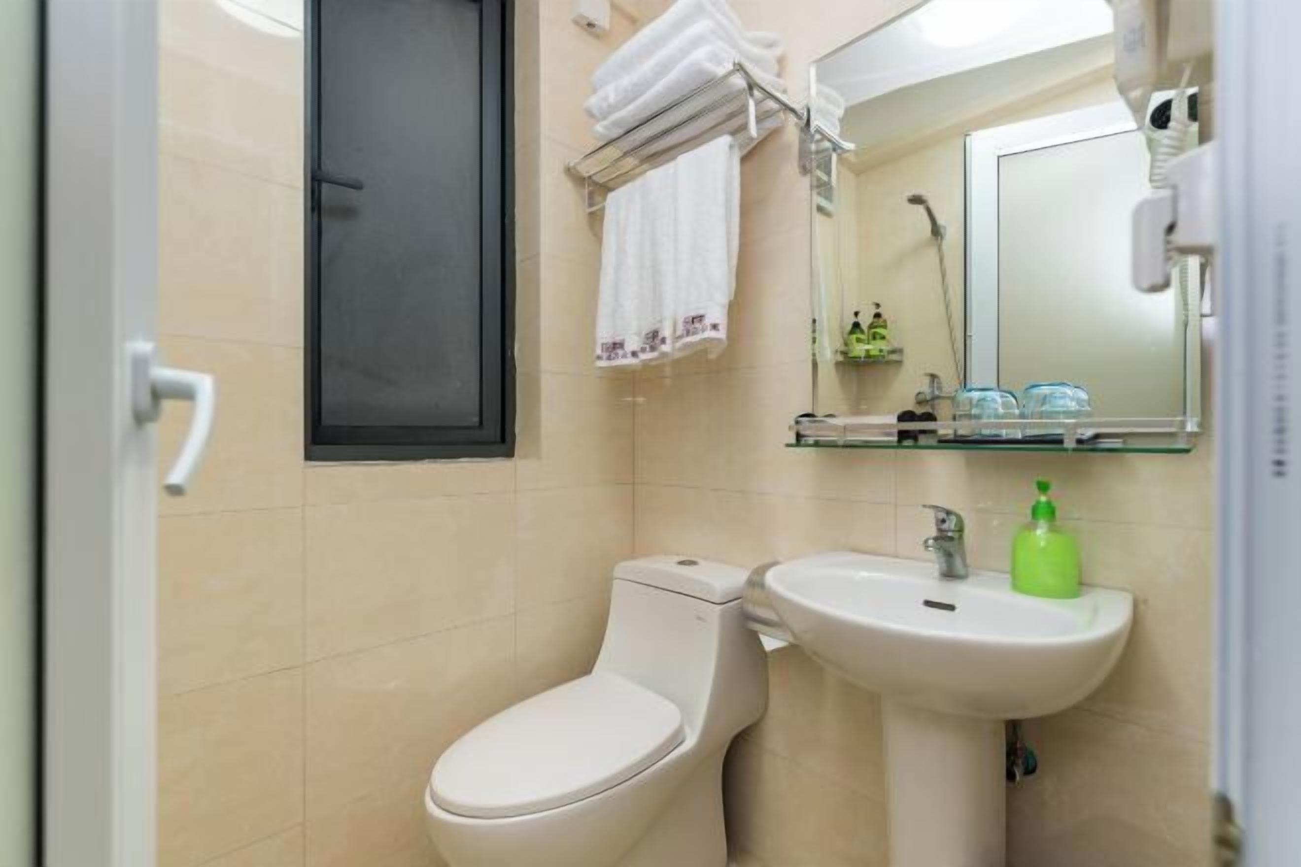 A bathroom with a toilet, sink, and mirror.