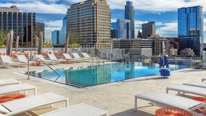 A rooftop pool with lounge chairs and a cityscape view. - Cozy 1-bedroom with WIFI,BBQ, pool, and gym in awesome Austin (Austin)