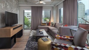 A modern living room with a flat-screen TV, a sofa, a coffee table, and a ceiling fan. - Cozy 1-bedroom with WIFI,BBQ, pool, and gym in awesome Austin (Austin)