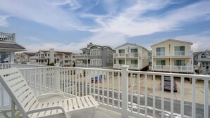 Un balcon avec des balustrades blanches donnant sur une rangée de maisons situées en bord de mer.