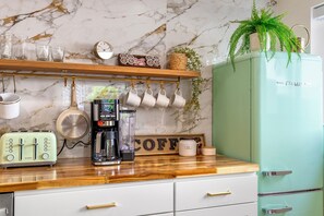 Enjoy cooking in this stylish kitchen with a refrigerator, coffee maker, and ample counter space.