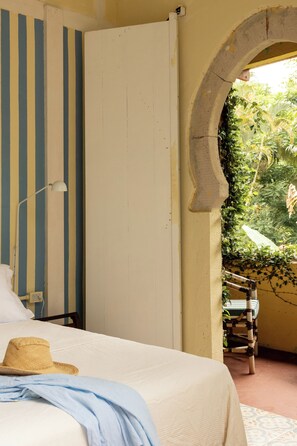 A bedroom with a bed, a hat, and a lamp. - O Portalzinho (Paraty)
