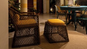 A dining area with a round table, chairs, and a hanging light fixture. - O Portalzinho (Paraty)