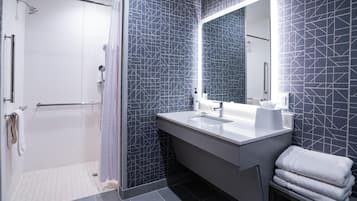 A modern bathroom with a shower, a sink, and a mirror.