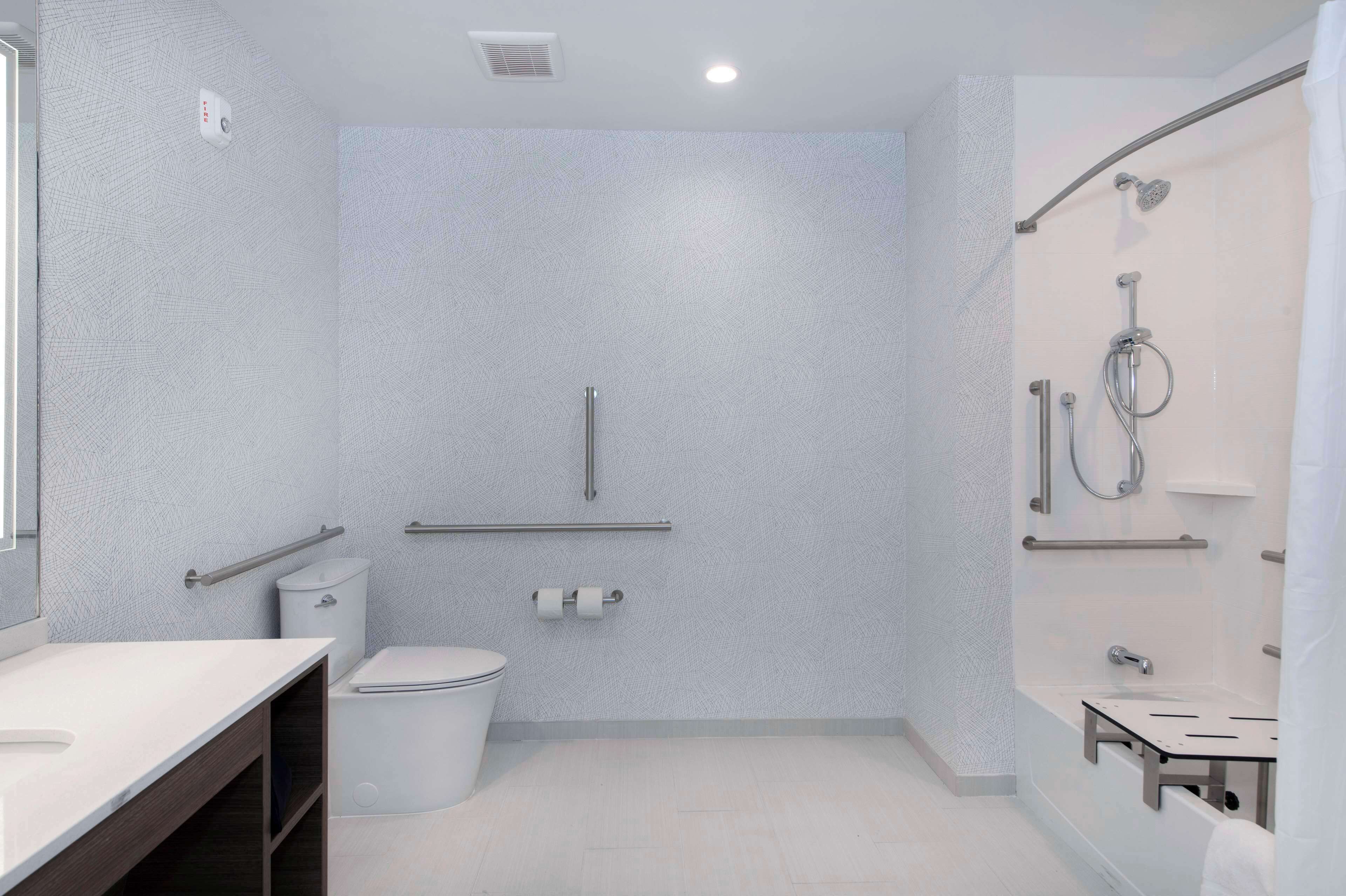 A modern bathroom with a shower, toilet, and sink.